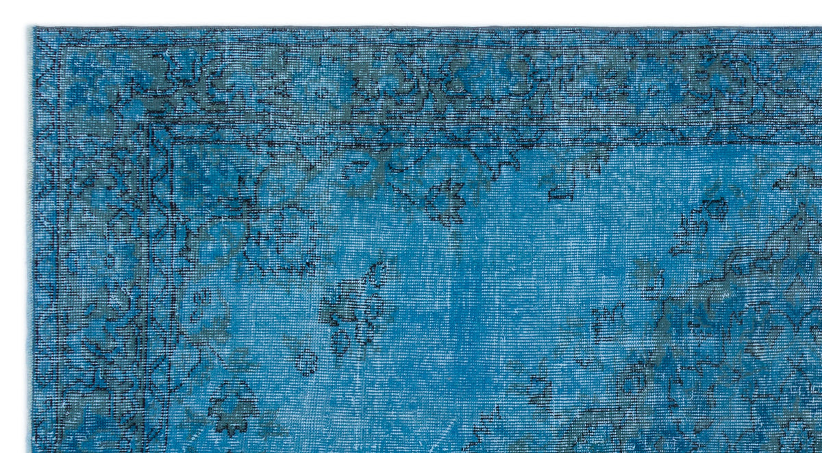 Bright blue distressed rug with a dark grey traditional floral border and faded medallion pattern.