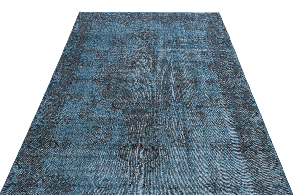 Blue and charcoal distressed rug with a traditional ornate medallion pattern on a white background.
