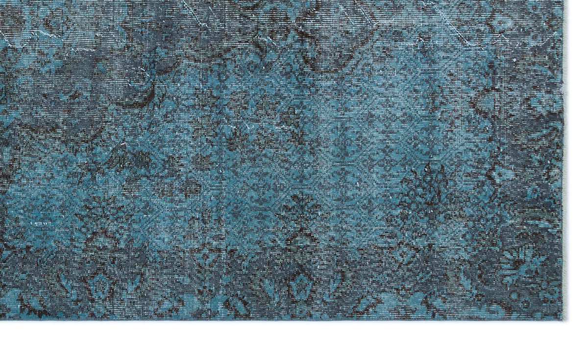 Teal and charcoal distressed rug with a faded traditional Persian-style floral pattern.