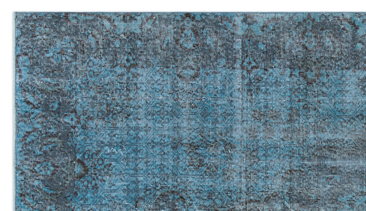 Teal and charcoal blue rug with a distressed, faded traditional medallion pattern.