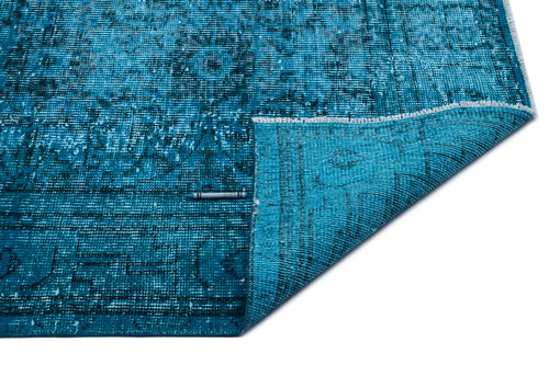 Load image 1 in gallery view. Bright blue distressed rug with a traditional medallion pattern, shown with a corner folded over on a white background.