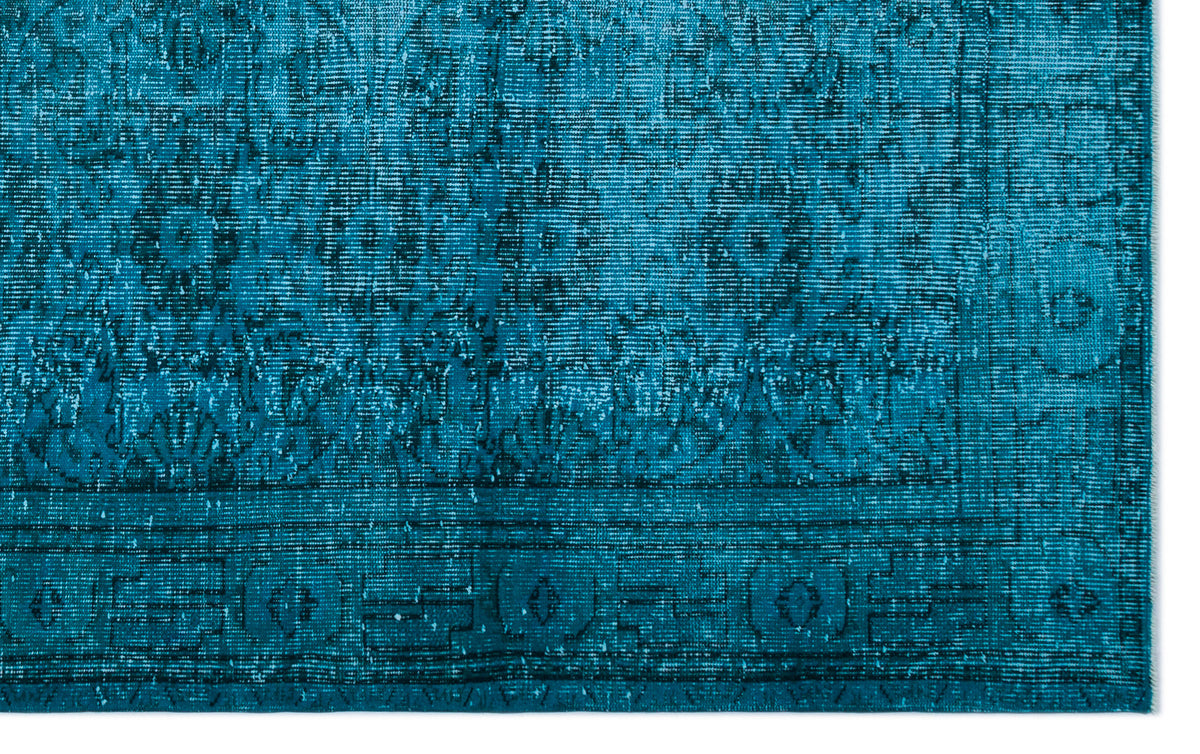 Teal distressed rug with a faded traditional medallion pattern and a geometric border.