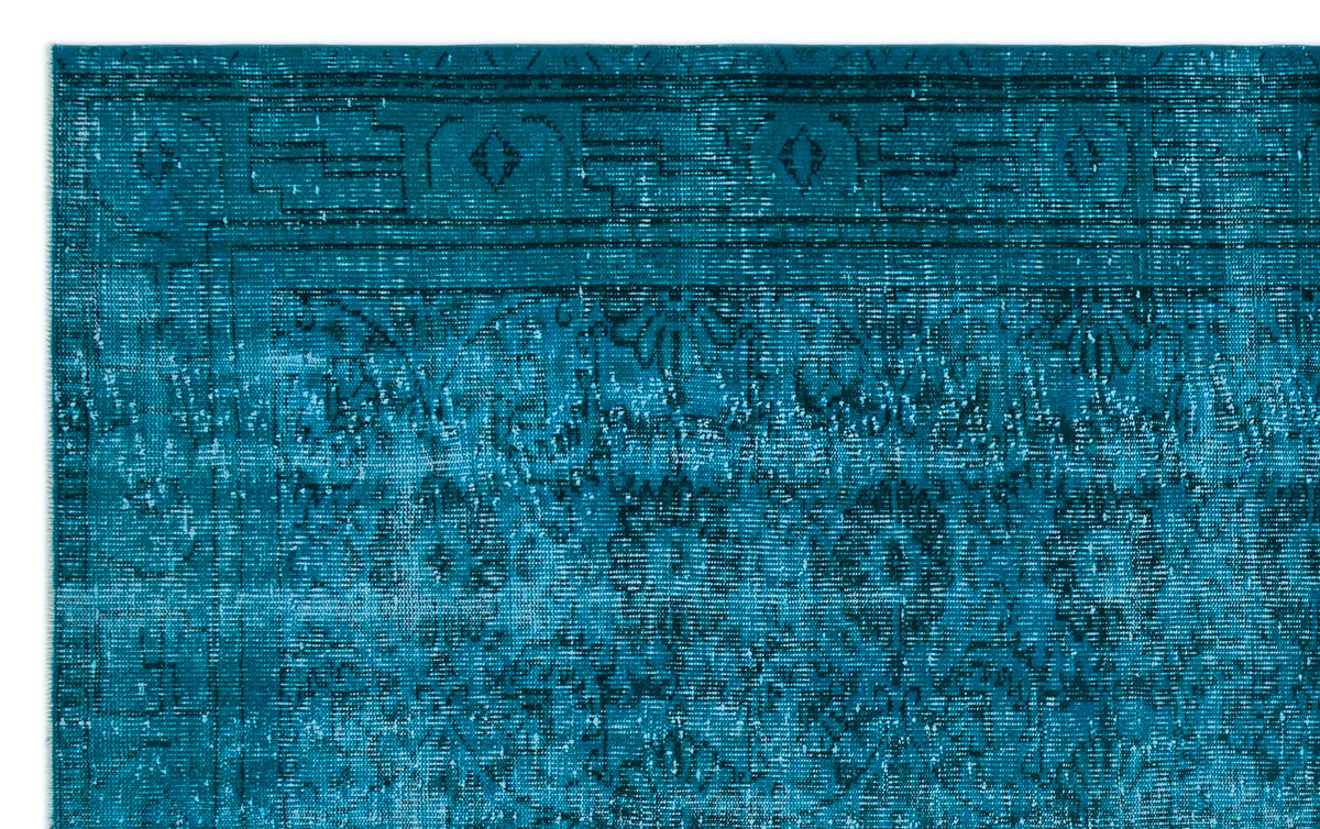 Teal distressed rug with a traditional floral medallion pattern and a geometric border.