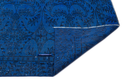 Load image 1 in gallery view. Bright blue rug with a black floral medallion pattern and a folded corner revealing the textured backing.