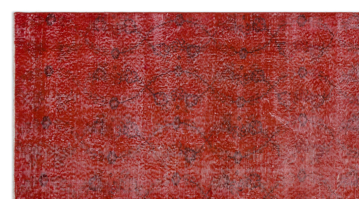 Distressed red rug with a faint, dark grey traditional medallion pattern.