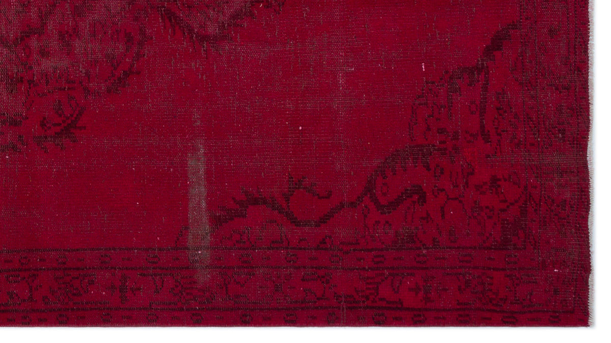 Deep red vintage-style rug with a distressed black floral border and faded traditional motifs.