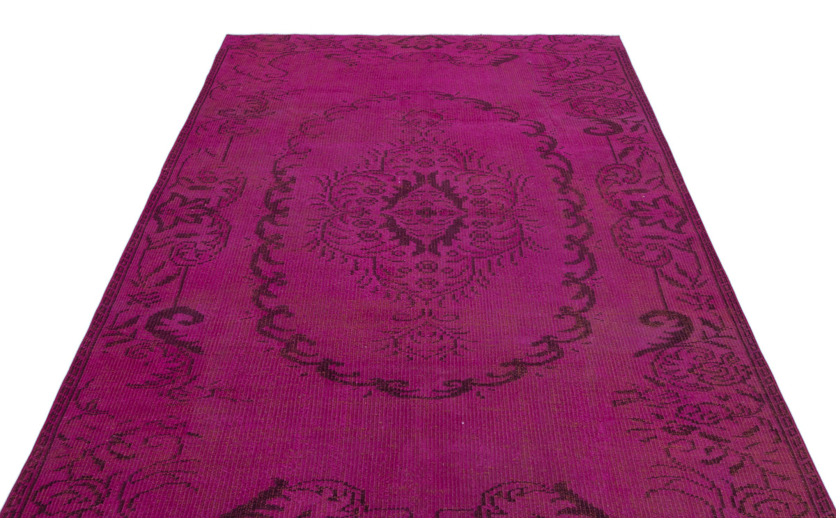 Magenta and black vintage-style rug with a central floral medallion and ornate border pattern.