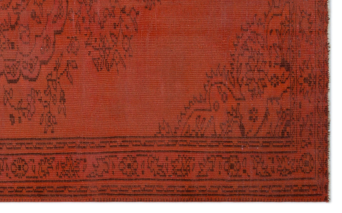 Rust-colored rug with a dark brown traditional floral border and medallion pattern on a white background.