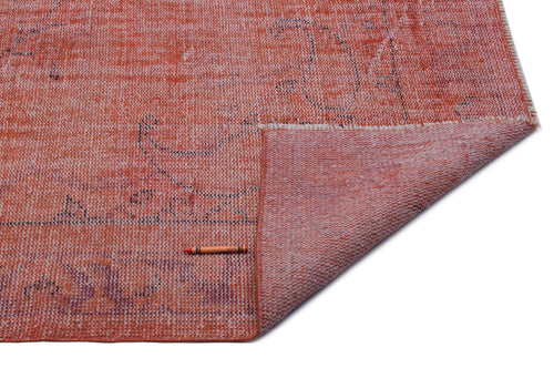 Load image 1 in gallery view. Distressed orange rug with a faded black paisley pattern and a folded corner showing the textured backing.