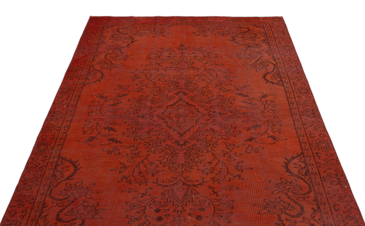 Distressed red rug with a dark brown traditional floral medallion and border pattern on a white background.