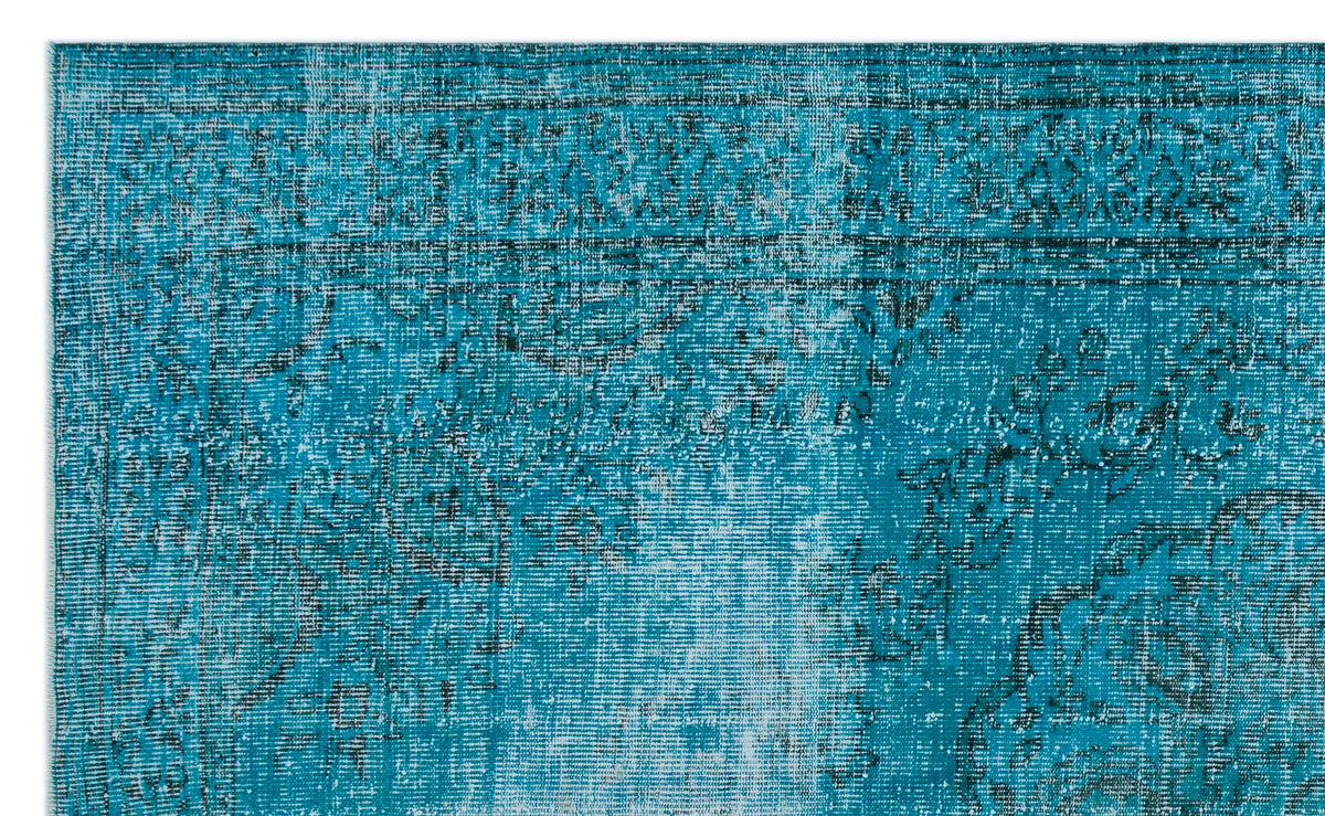 Teal and black distressed rug with a faded traditional medallion pattern.