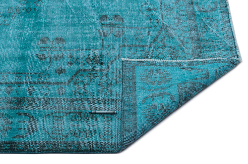 Load image 1 in gallery view. Turquoise and black distressed rug with a traditional medallion pattern, shown with a corner folded over on white.