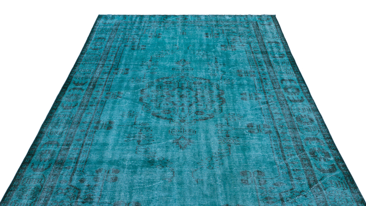 Teal and black distressed vintage-style rug with a central medallion and ornate border pattern.