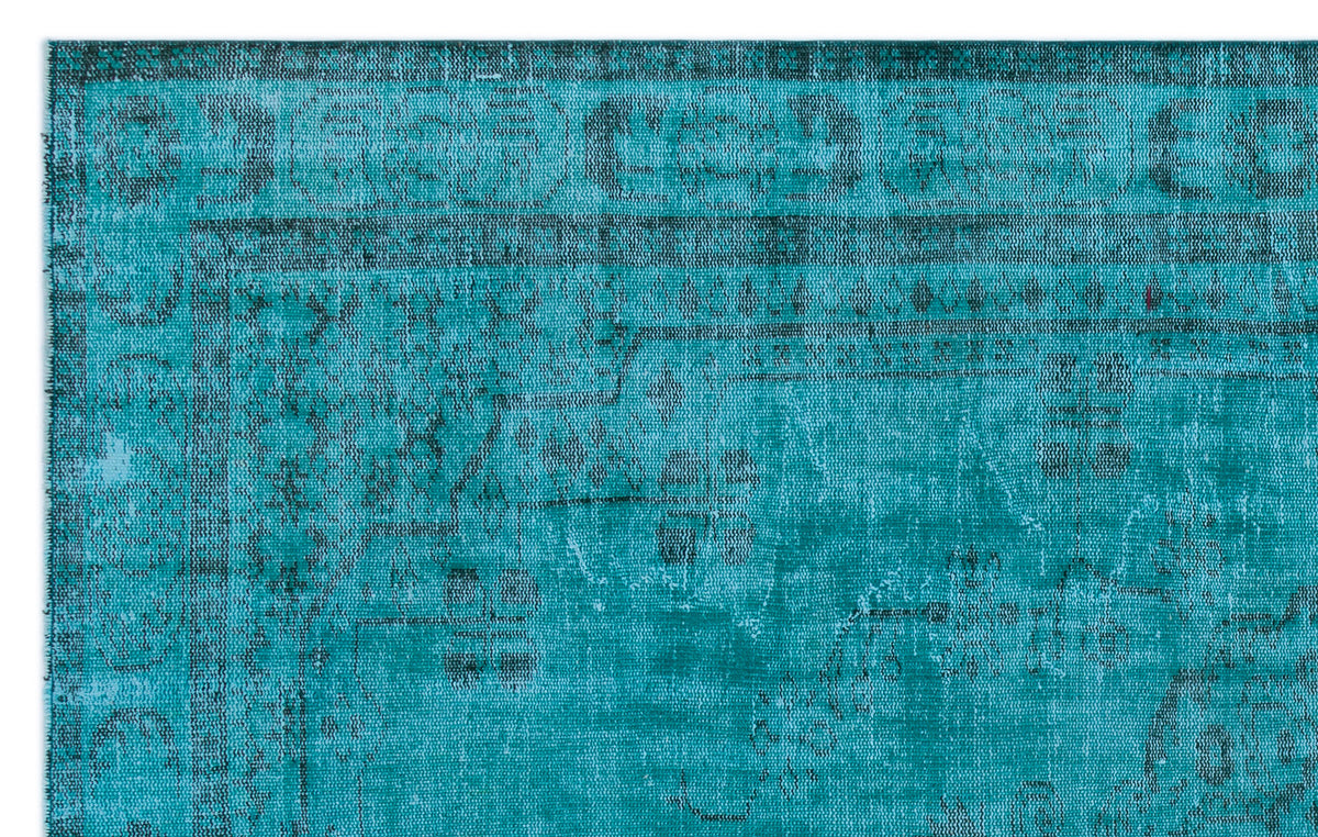 Teal and black distressed traditional rug with a faded ornate border and geometric medallion pattern.