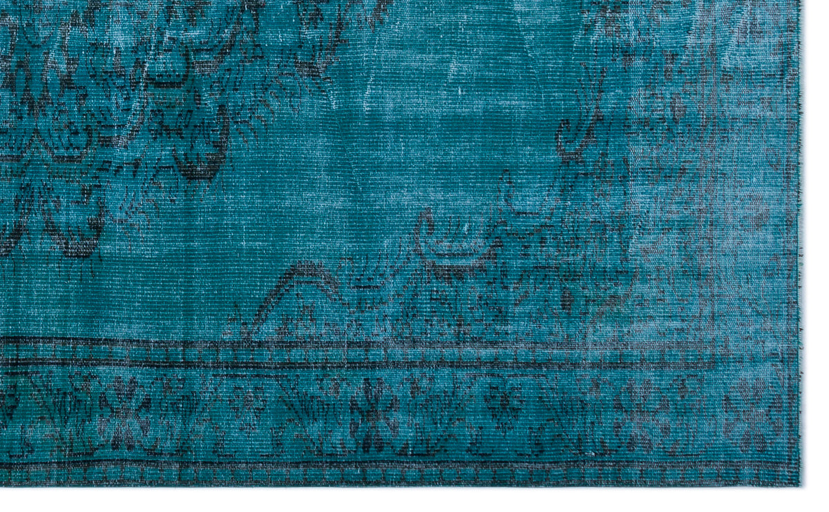 Teal and black distressed rug with a faded traditional medallion pattern and a linear border.