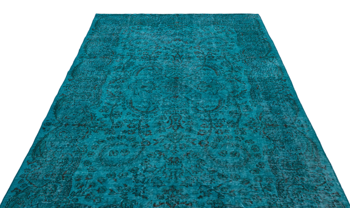 Teal distressed rug with a dark floral medallion pattern on a white background.