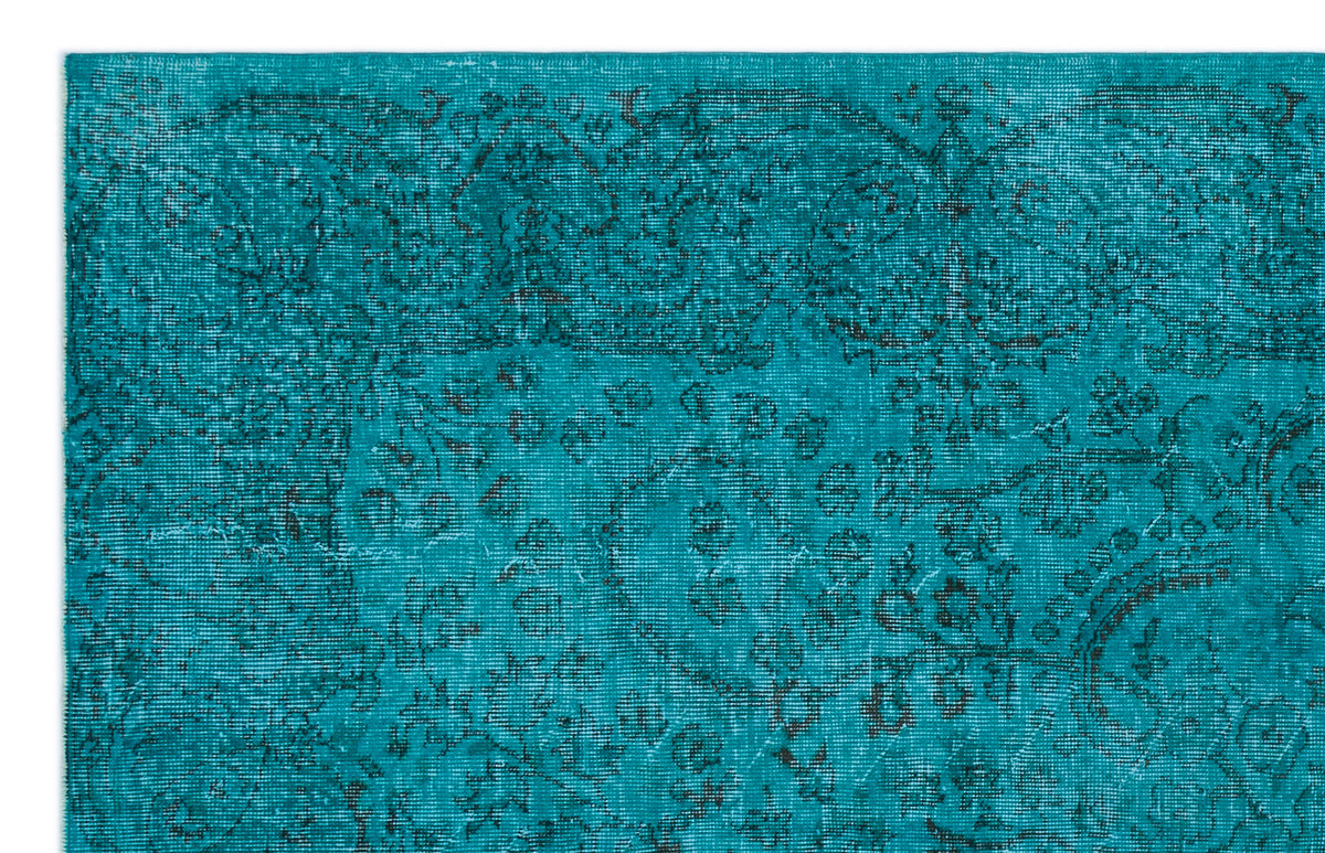 Teal rug with a distressed, dark charcoal traditional floral medallion pattern.