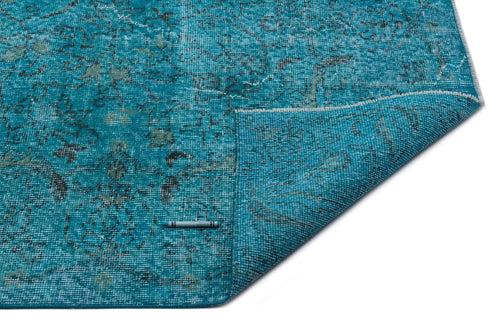 Load image 1 in gallery view. Teal distressed rug with a faded floral pattern and a folded corner, isolated on a white background.