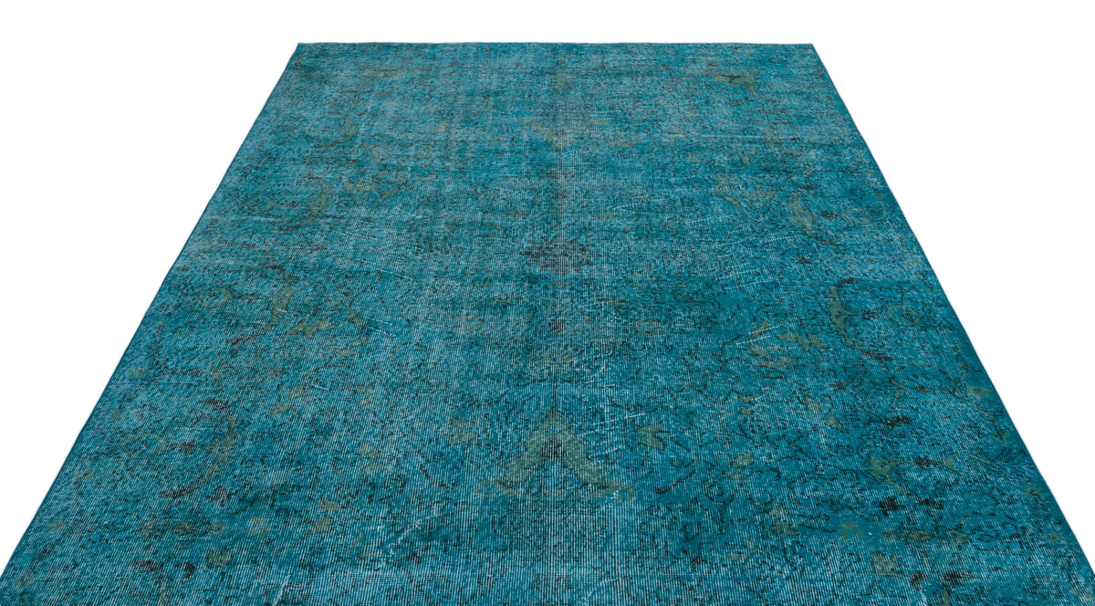 Teal distressed area rug with a faded traditional medallion pattern on a white background.