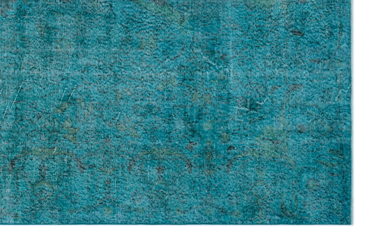 Teal distressed rug with a faint, dark grey traditional floral pattern.