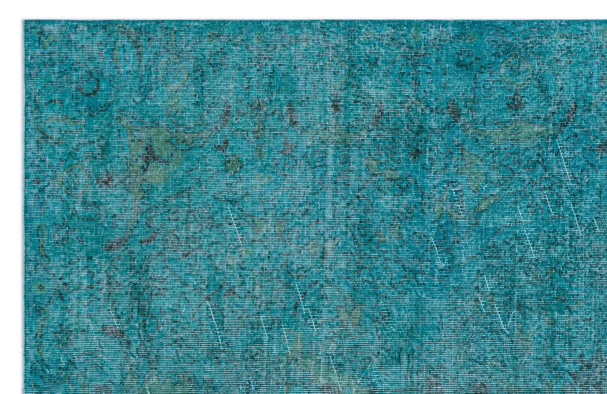 Teal and black distressed rug with a faded traditional floral medallion pattern.