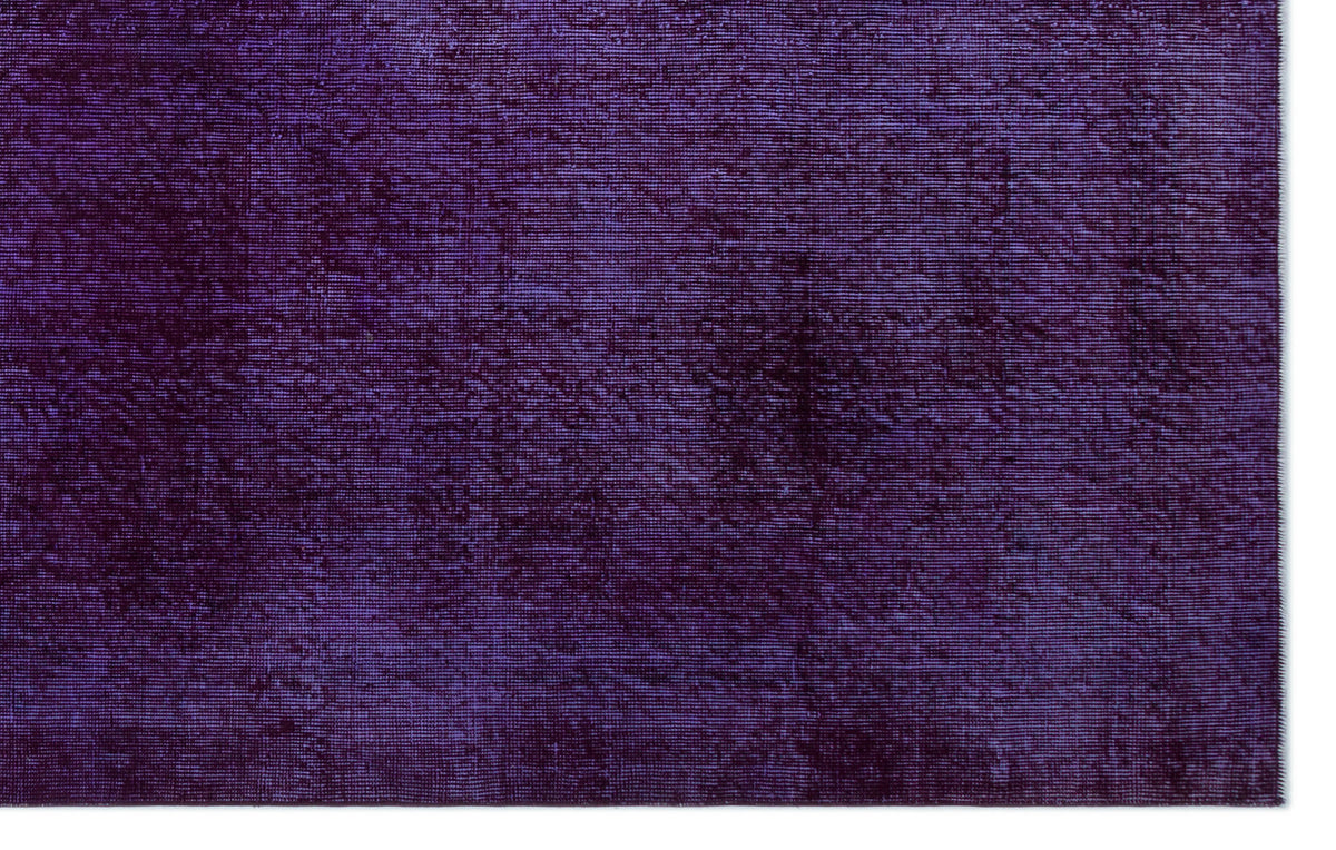 Deep purple solid-color rug with a subtle, distressed texture and horizontal weave pattern.