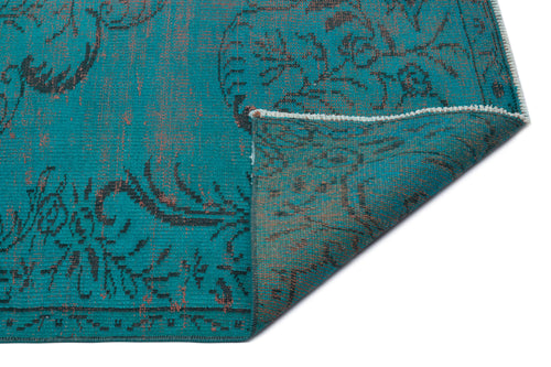 Load image 1 in gallery view. Teal rug with a distressed black floral pattern and a folded corner revealing the underside.
