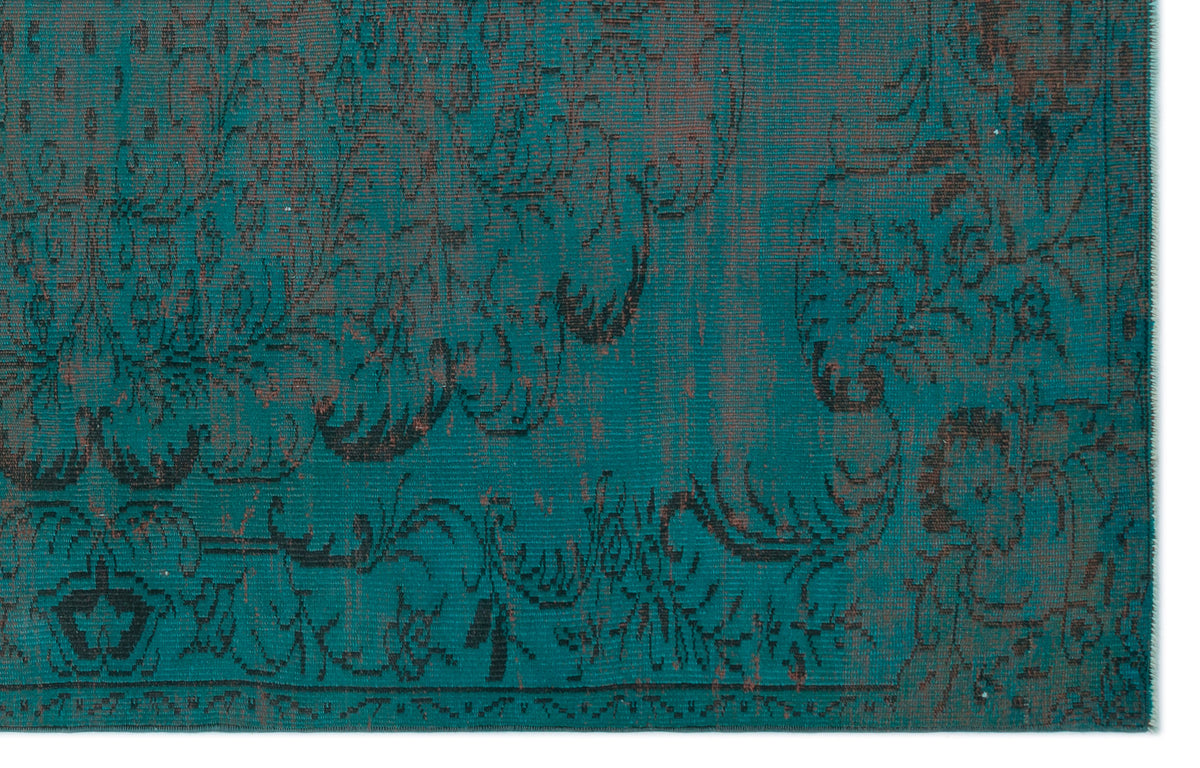 Teal and dark brown rug with a distressed, traditional floral medallion pattern.