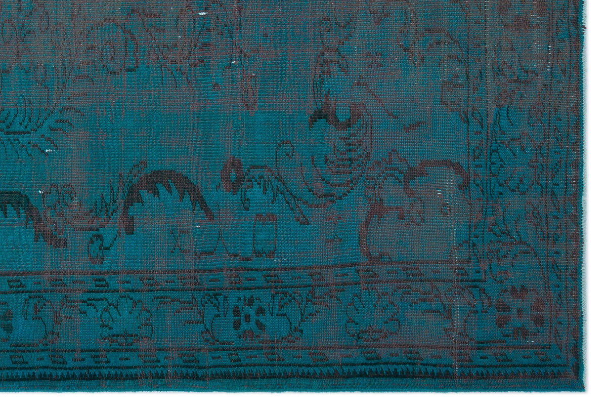 Teal and charcoal distressed rug with a faded traditional floral medallion pattern and a geometric border.