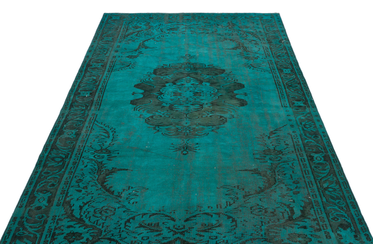 Teal and black distressed rug with a central medallion and ornate border pattern on a white background.