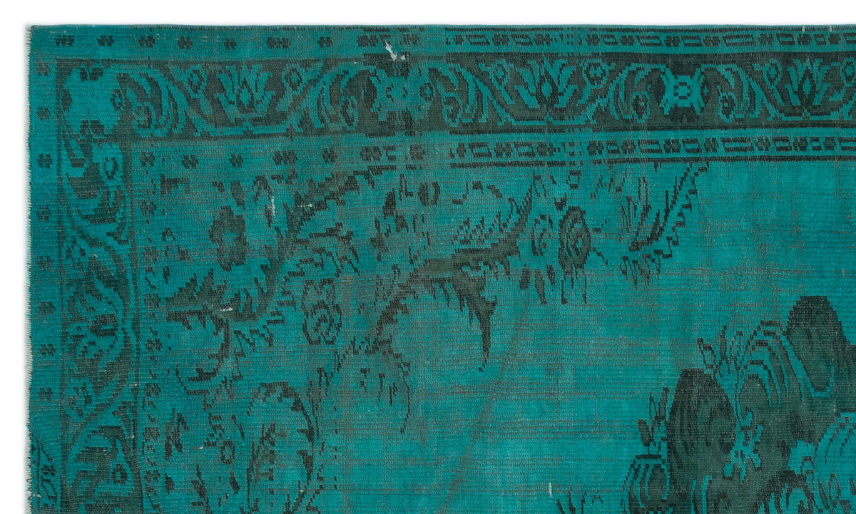 Teal and black rug with a distressed traditional floral border and central medallion pattern.