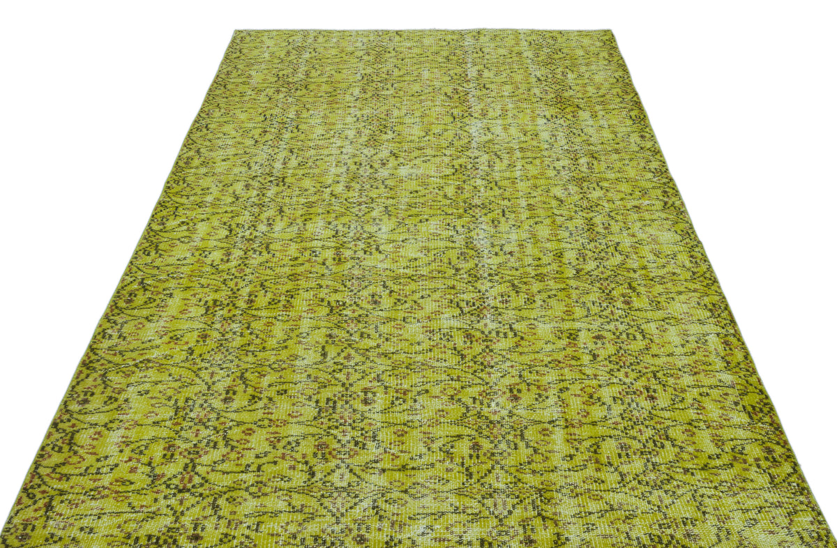 Chartreuse and brown vintage-style rug with a distressed, intricate floral medallion pattern on a white background.