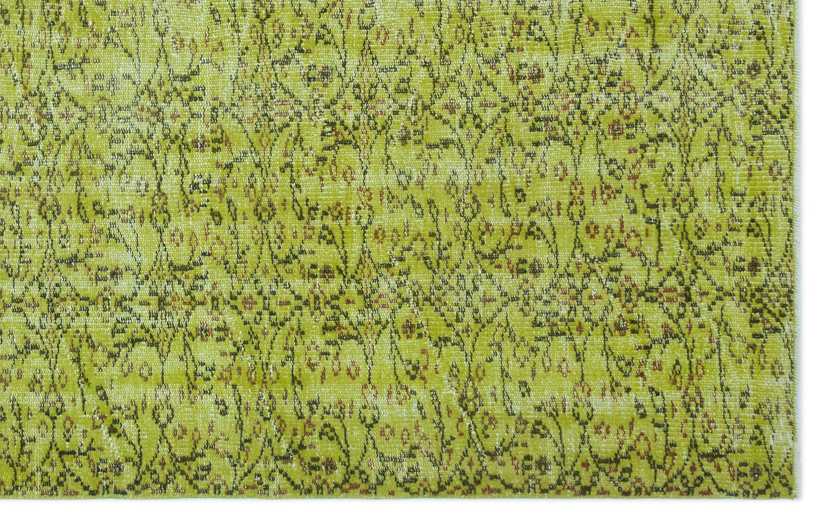 Chartreuse and olive green vintage-style rug with a distressed, intricate floral vine pattern.