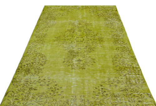 Load image 1 in gallery view. Chartreuse distressed rug with a faded central floral medallion and border pattern on a white background.