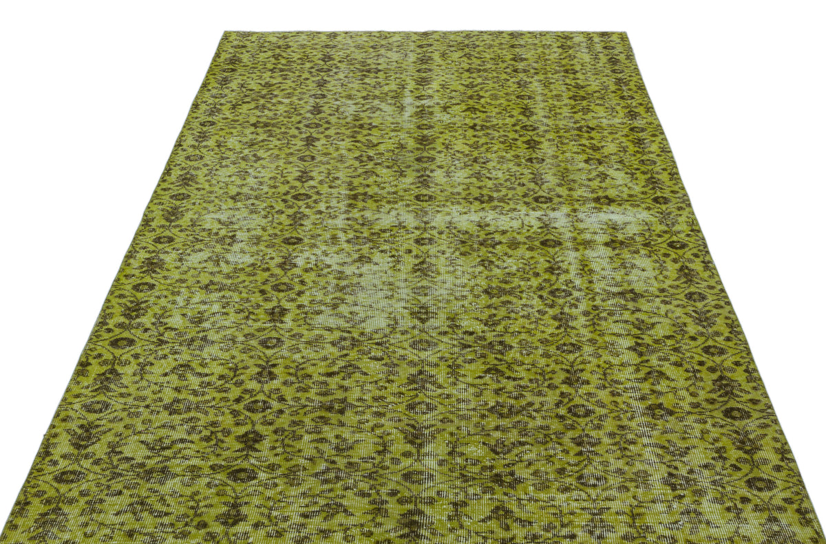 Chartreuse and dark brown distressed rug with an all-over traditional floral pattern.