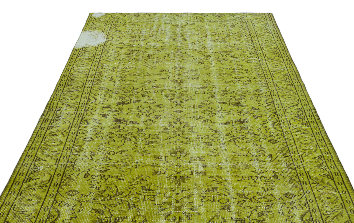 Chartreuse and brown distressed vintage-style rug with an intricate floral medallion pattern.