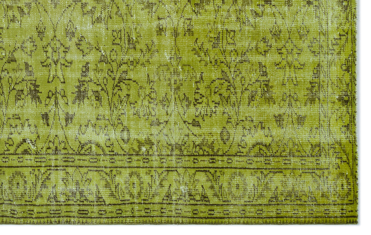 Chartreuse and brown distressed rug with a traditional floral medallion pattern and a detailed border.