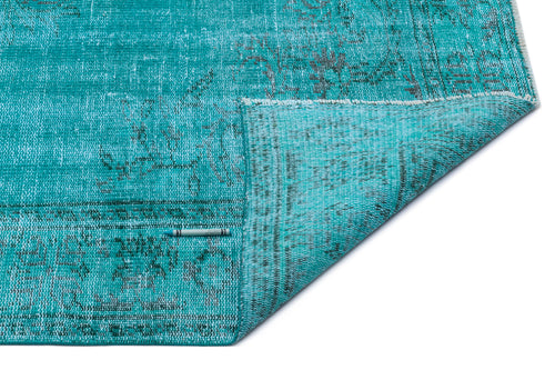 Load image 1 in gallery view. Distressed turquoise rug with a faded traditional pattern and a folded corner, isolated on a white background.