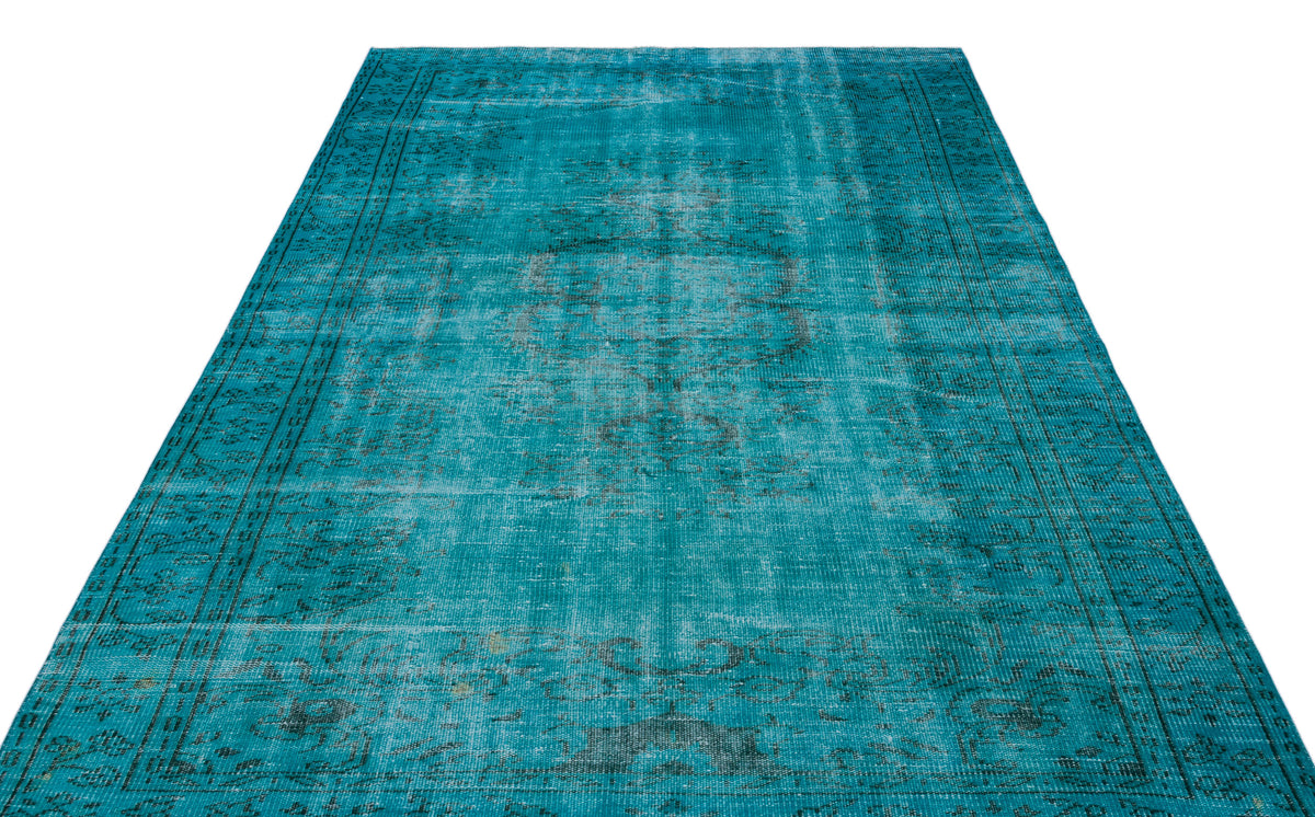 Teal distressed rug with a faded traditional medallion pattern and a dark border on a white background.