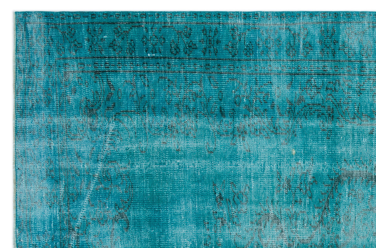 Teal distressed rug with a faded black traditional floral border and medallion pattern.