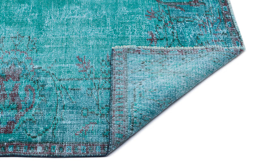 Load image 1 in gallery view. Teal distressed rug with a faded traditional medallion pattern and a folded corner, isolated on a white background.