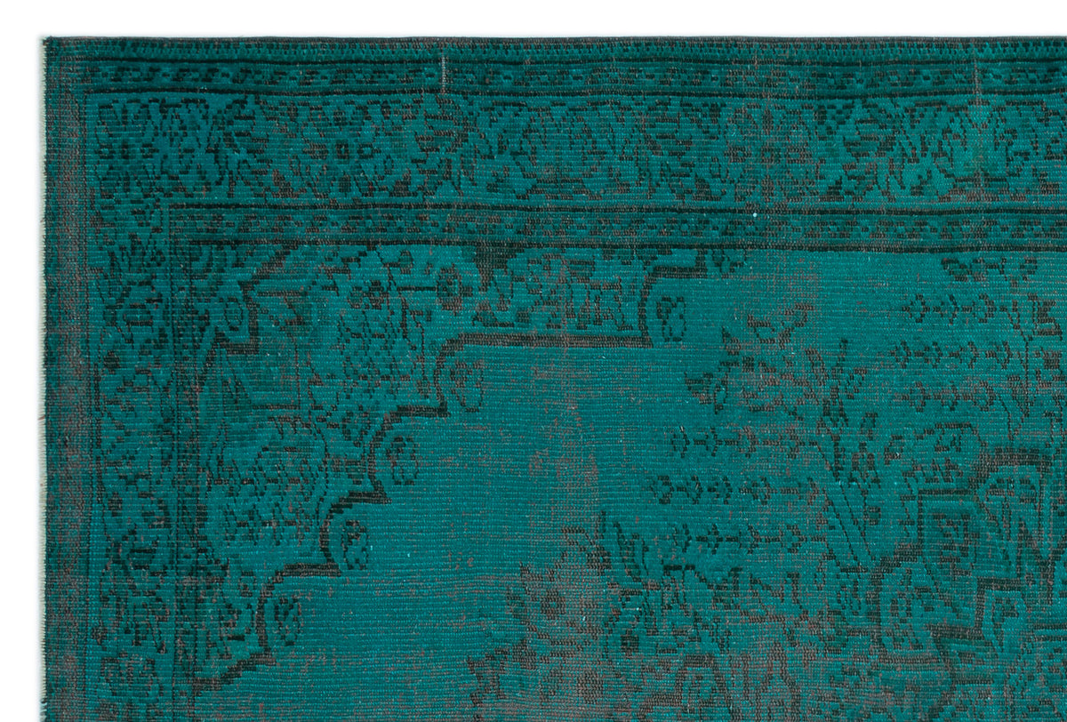 Teal and black rug with a traditional distressed floral medallion pattern and a detailed border.