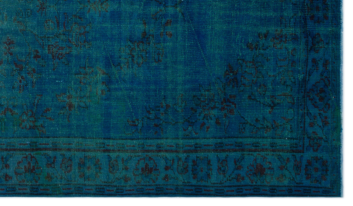 Deep teal vintage-style rug with a dark floral pattern and a decorative border.