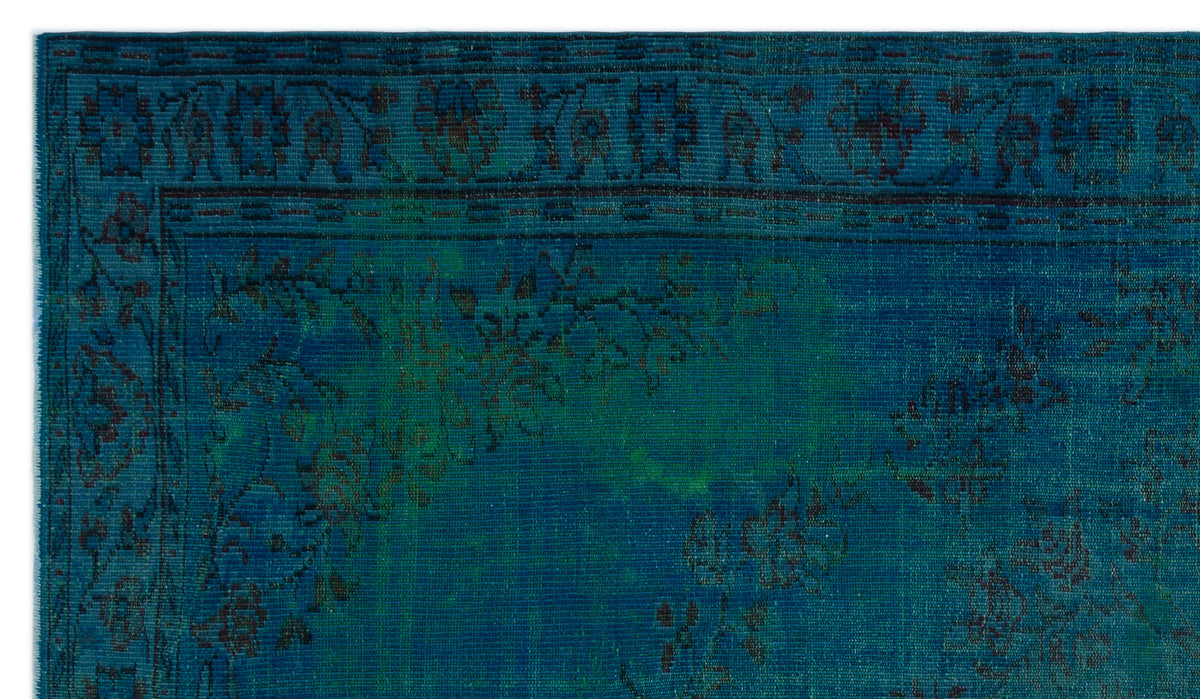 Deep teal and blue vintage-style rug with a dark floral border and distressed botanical pattern.
