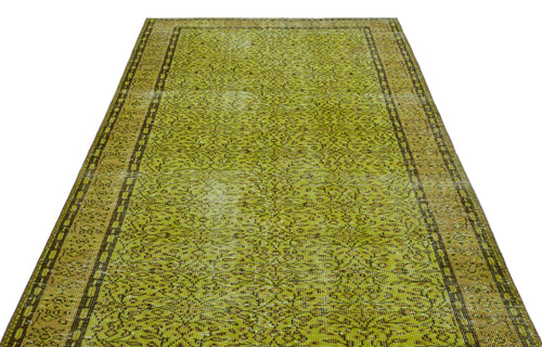 Load image 1 in gallery view. Chartreuse and brown vintage-style rug with a distressed floral medallion pattern and a geometric border.