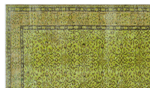 Load image 1 in gallery view. Chartreuse and brown vintage-style rug with a distressed floral medallion pattern and a geometric border.