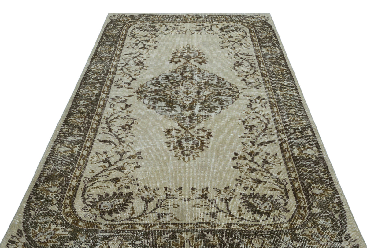 Beige and brown traditional rug with a central floral medallion and ornate border on a white background.