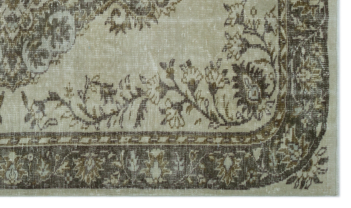 Beige and brown vintage-style rug with a distressed floral medallion pattern and a decorative border.