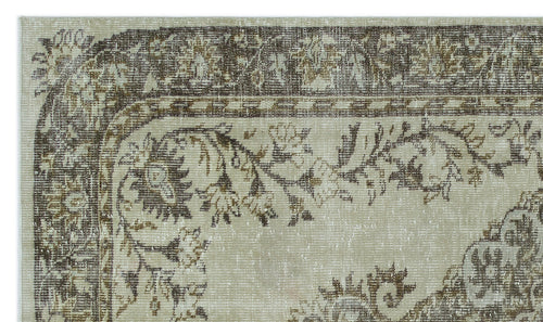 Load image 1 in gallery view. Beige and brown distressed rug with a traditional floral border and central medallion pattern.