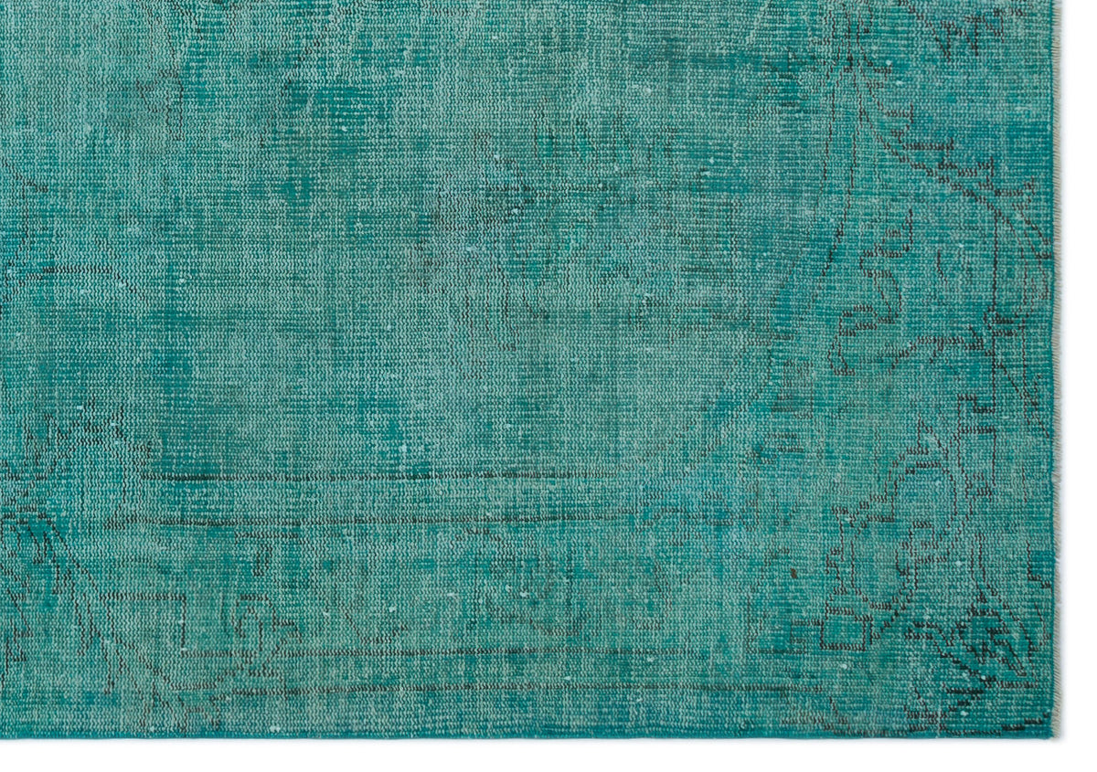 Teal distressed rug with a faded traditional medallion pattern and visible weave texture.